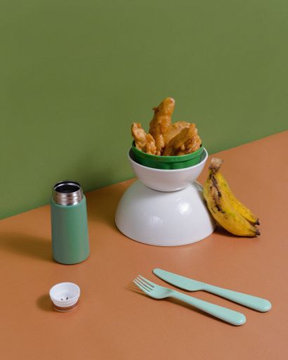 A vertical shot of fried bananas on a green and brown background