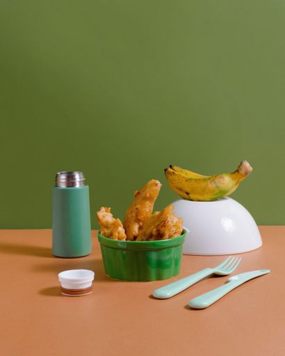 A vertical shot of fried bananas on a green and brown background