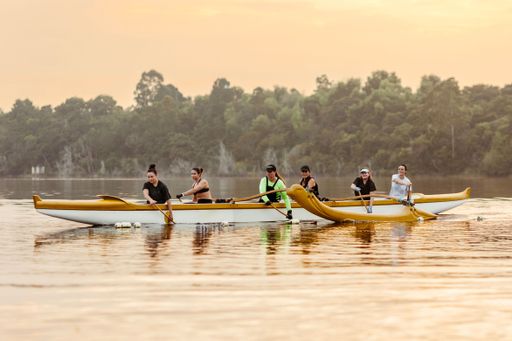 The people in a small boat sailing on a calm lake.