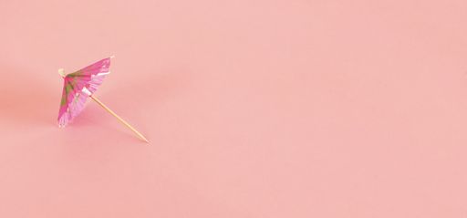 A high angle shot of a pattern with pink cocktail sun umbrella