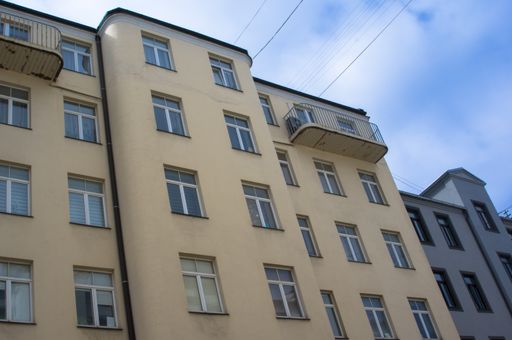 A low angle shot of a building's facade under a cloudy sky