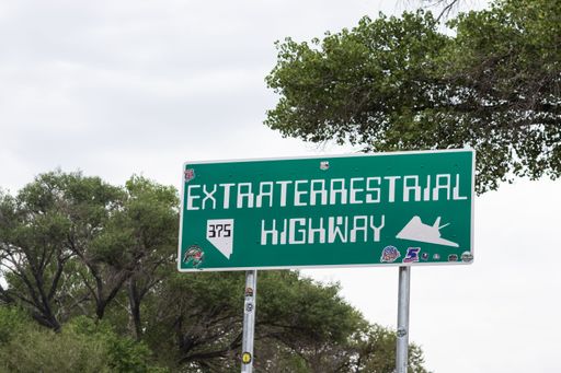 A colorful extraterrestrial highway sign visible in the foreground of a landscape