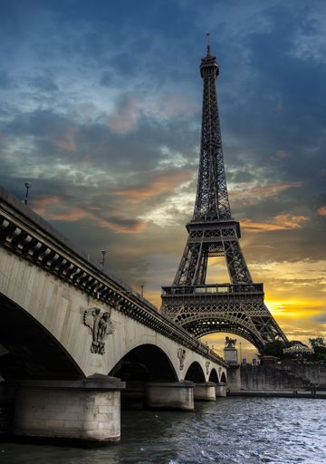A vertical shot of the Eiffel Tower in Paris France near the river Seine at sunset