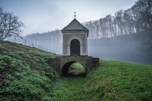 A brick chapel in a forest on the St. Anne Mountain covered in the fog in Opole, Poland