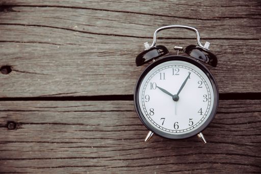 A closeup of an alarm clock on a wooden background