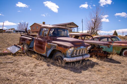 An old rusty truck against beautiful sky in the junkyard
