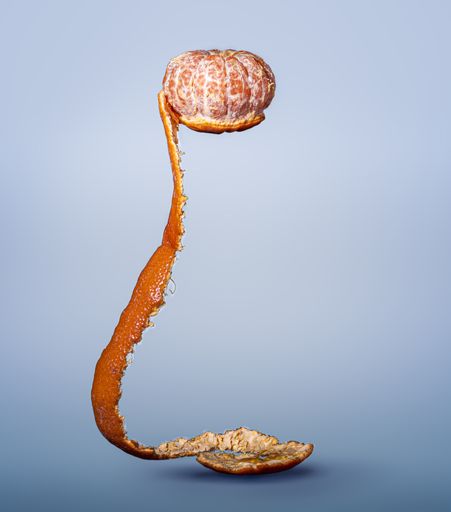 A vertical shot of fresh ripe tangerine with peel isolated on white background