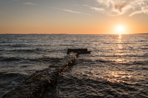 The mesmerizing view of the ocean and a pier under colorful sky during sunset in Dalmatia, Croatia