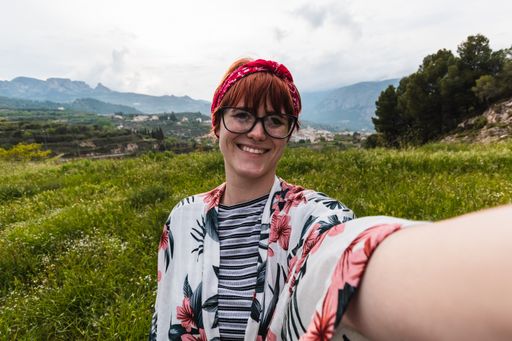 A Caucasian female taking a selfie in nature