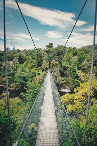 A high-angle view of a steel bridge in the mountains on a cloudy day