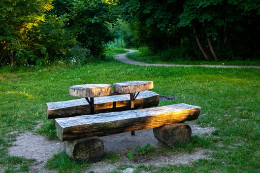 A wooden bench made with tree logs in a park