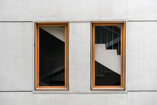 A closeup shot of a concrete wall of a building with two glass window