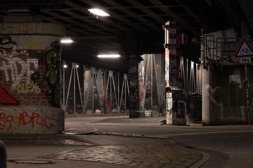 An urban scene featuring a street lined with street lamps and adorned with vibrant graffiti art on the wall Hamburg Germany Deutschland Hafen Hafencit