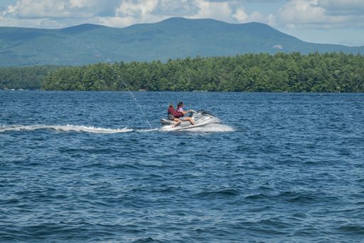 Two people riding a jet ski on Lake Winnipesaukee in New Hampshire