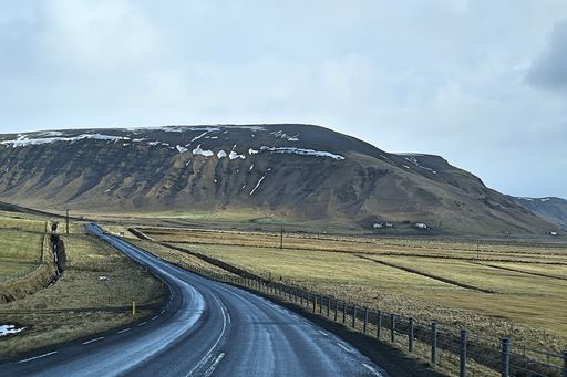 The gloomy sky over the hills captured from the narrow asphalt road