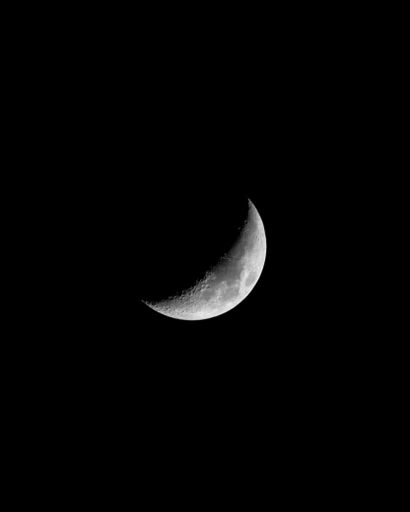 A stunning crescent moon illuminating the night sky against a dark backdrop