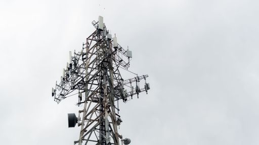 A majestic view of an old radio tower illuminated against a clear blue sky, perfect for mobile phone and communication industry concepts