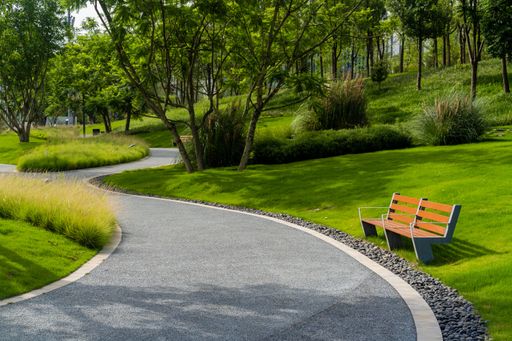 A scenic view of an asphalt road in a green park