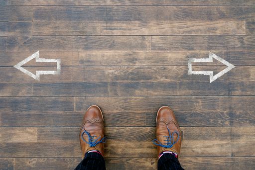 An overhead shot of a person standing in the middle of two arrows