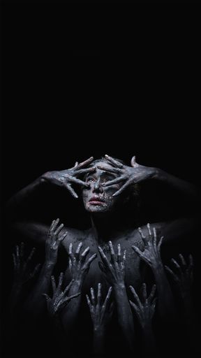 Halloween concept of fancy makeup of scary witch with demon hands raising from below in dark background