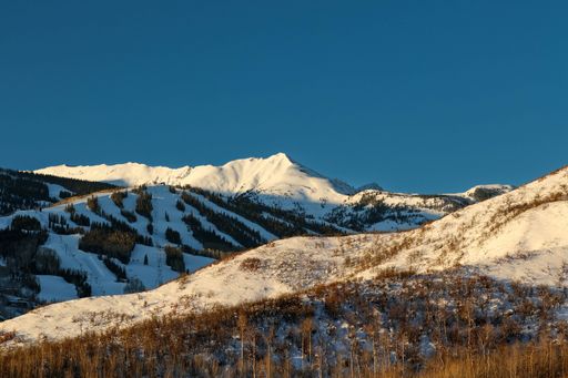 A breathtaking winter landscape with snow-capped mountain peaks and trees in Snowmass at Aspen