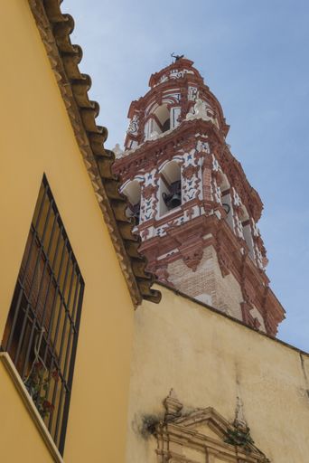 A vertical shot of the Church of San Juan under a blue sky in Ecija, Spain