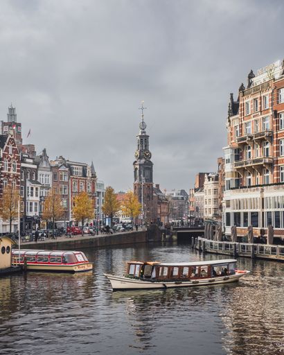 Amsterdam, Netherlands - November 28 2022: A postcard view of Amsterdam centre. Rokin and Munttoren as seen from the river Amstel in autumn.