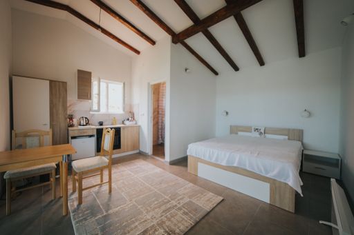 A bright modern attic room with a king-size bed and wooden furniture