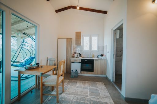 A minimalistic weekend home room interior with a small kitchen and a queen-size bed
