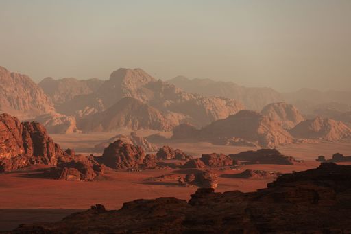 This stock photo shows a stunning view of a desert landscape, featuring majestic mountain ranges in the background