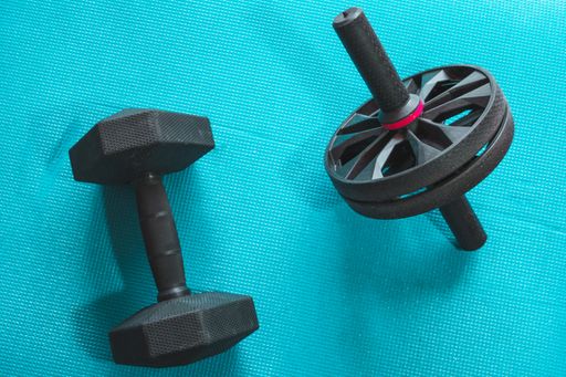 A high angle shot of heavy dumbbells placed on a yoga mat