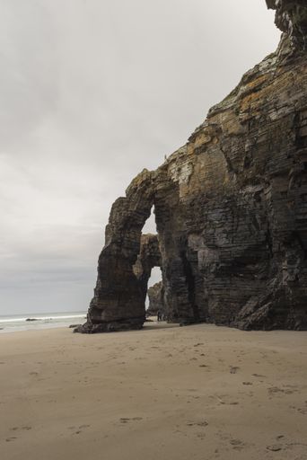 A vertical shot of rocky cliffs on the As Catedrais beach surrounded by the sea in Spain