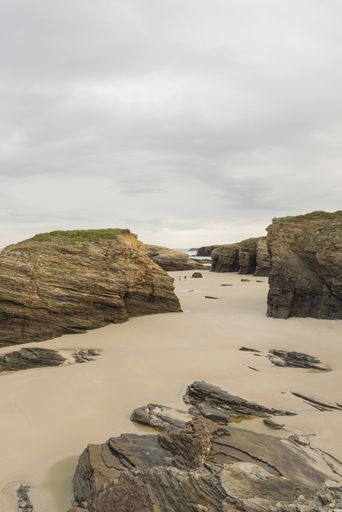 A vertical shot of rocks on the seashore in the Galicia, Spain
