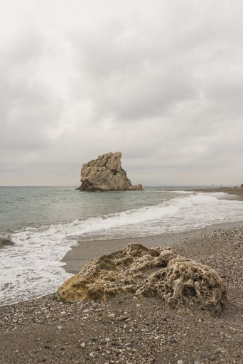 A vertical shot of a big rock on the beach of Malaga, Andalucia, Spain