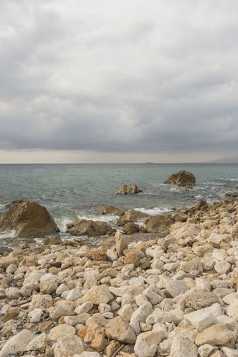 A vertical shot of big and small stones on the beach of Malaga, Andalucia, Spain
