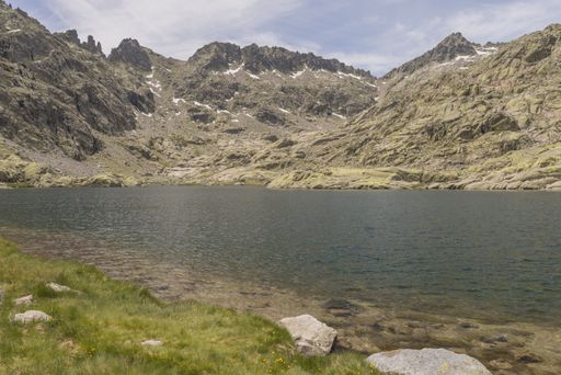 A beautiful view of a river surrounded by Gredos mountain range under a cloudy sky in Candeleda, Spain