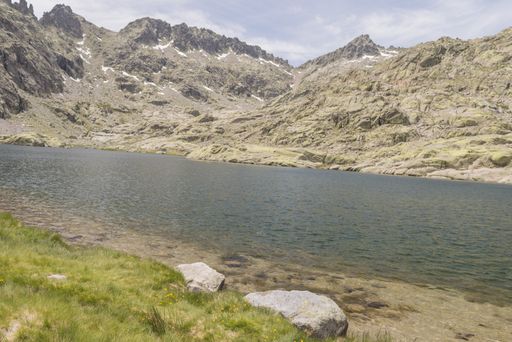 A beautiful view of a river surrounded by Gredos mountain range under a cloudy sky in Candeleda, Spain