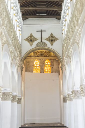 a vertical shot of a religious building interior with white walls and arches in Toledo Spain