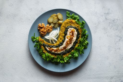 A top view of eggplant curd with vegetables on a plate on a white surface