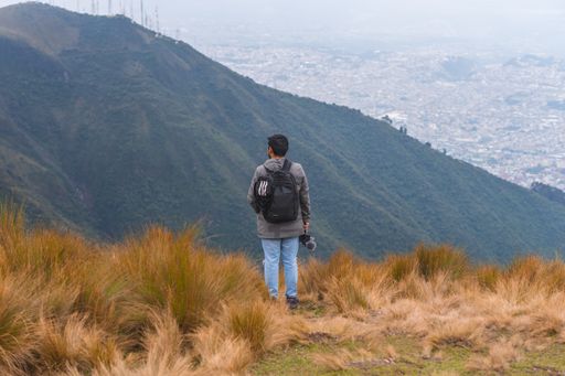 A young guy hiking in mountains and enjoying the beautiful view
