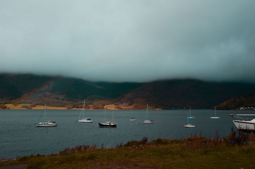 A scenic view of a boats in a lake in  in the Scottish Highlands on a cloudy day