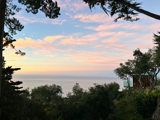 A stunning sunset over a picturesque landscape with trees in the foreground
