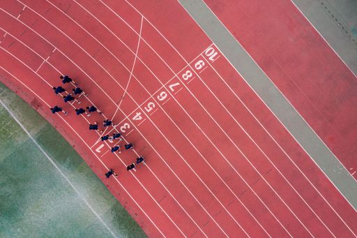 An aerial view of a running track with a group of runners.