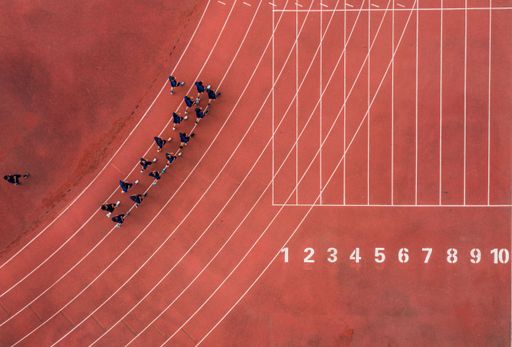 An aerial view of a running track with a group of runners.