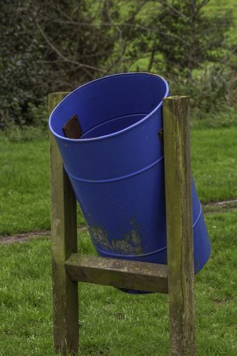 big blue trash can be placed in a park to litter and help recycle waste giving them a second life