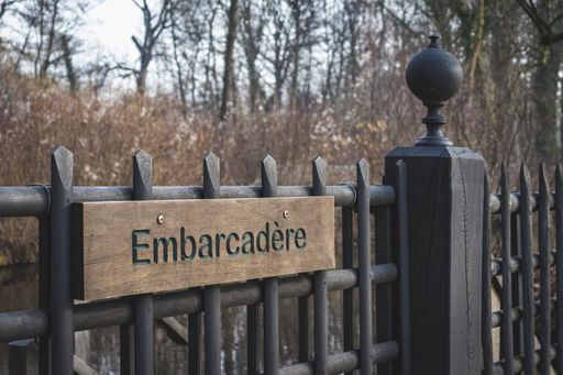 A closeup shot of a custom wooden fence with the sign "Embarcadere", which is French for jetty