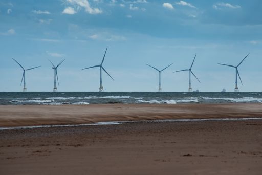 An aerial view of a wind turbine along the coastline