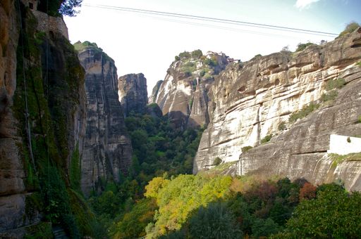 The Meteora rock formations in Thessaly, Greece with colorful trees beneath the shade of cliffs