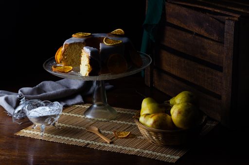 A closeup shot of a tasty orange cake, yogurt, and pear on the table