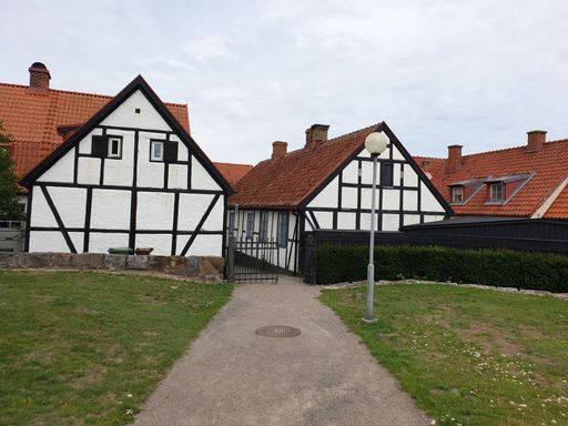 A pathway to the traditional black and white two-story houses in a rural countryside